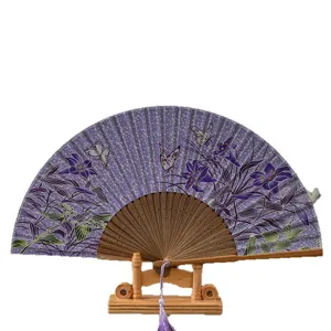 Japanese style folding fan with elegant purple floral butterfly pattern and wooden display stand