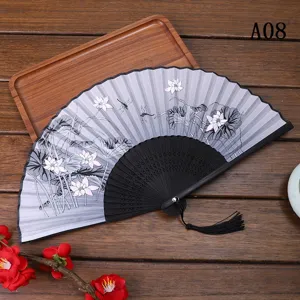 Vue détaillée du ventilateur pliant traditionnel avec élégant motif de lotus et de libellule.