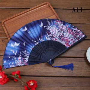 Vue détaillée du éventail pliant traditionnel avec motif papillon floral et pompon.