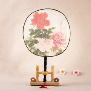 Éventail rond traditionnel chinois en soie avec imprimé pivoine et support en bois.