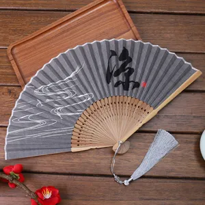 Traditional Chinese folding fan with linen fabric, bamboo ribs, and elegant tassel pendant.