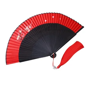 Traditioneller chinesischer Fächer in Rot und Schwarz mit Pflaumenblüten und roter Quaste.