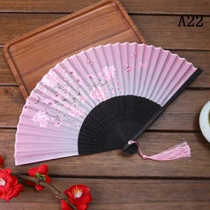 Éventail pliant rose avec motif de fleurs de cerisier et gland pour la danse et usage quotidien.