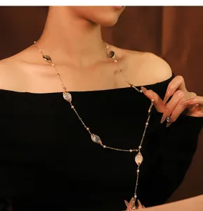 Elegante collana lunga da maglione con dettagli in madreperla naturale e perle.