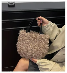 Detailed view of fluffy curly faux fur handbag with black leather handles, soft texture.