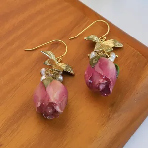 Boucles d'oreilles de roses naturelles faites à la main avec perles et crochets dorés.