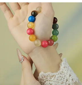 Primer plano de pulsera de cuentas de piedra natural colorida en la muñeca, moda.