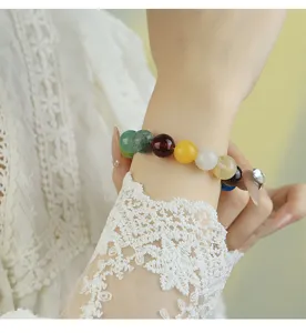 Primer plano detallado de una pulsera de cuentas de piedra natural colorida estilo macaron.