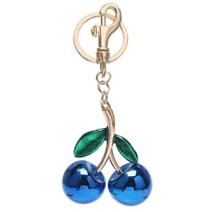 Blauer Kirschen Schlüsselanhänger für Handtasche, glänzendes Frucht-Design mit Gold und Grün.