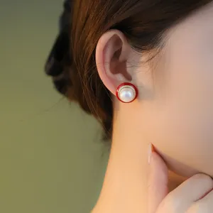 Nahaufnahme eleganter runder roter Emaille Perlen Ohrstecker für Frauen, luxuriöses Design.