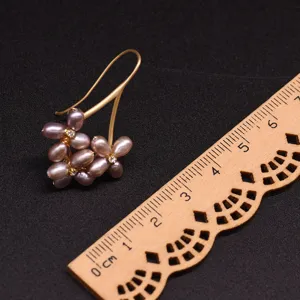Freshwater purple pearl flower earrings with gold hooks and sparkling zircon accents detail view.