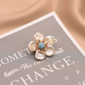 Exquisite baroque pearl flower brooch with central blue stone and sparkling zircon details.