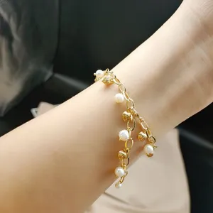 Elegant gold chain bracelet featuring delicate pearls and metal beads, stylish jewelry.