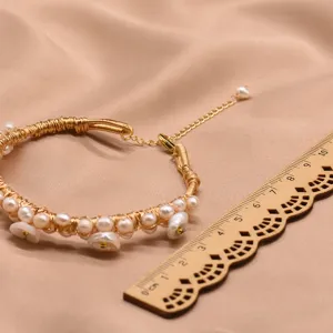 Exquisites Perlenarmband Detail mit filigranem Golddraht und echten Naturperlen.