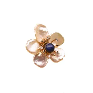 Baroque pearl flower brooch featuring natural irregular pearls and a chic blue gemstone core.