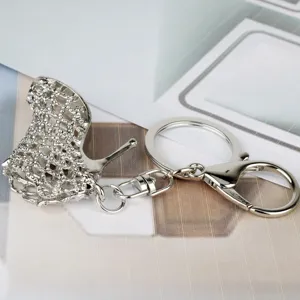 Detail close-up of a stylish silver high heel shoe metal keychain keyring pendant.