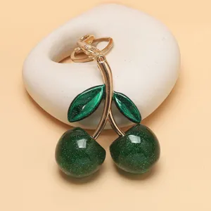 Grüner Kirsch-Schlüsselanhänger Detail, modischer Taschenanhänger mit glänzendem Finish.