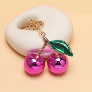 Nahaufnahme des glänzenden rosa Kirsch Metall Schlüsselanhängers und Taschenanhängers.
