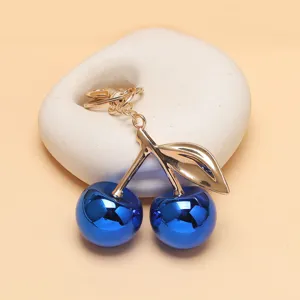Nahaufnahme Detailansicht des eleganten blauen Metallkirschen Anhängers mit goldenem Stiel.