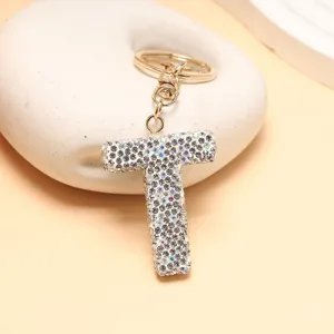 Nahaufnahme des glitzernden Strass-Buchstaben-T-Schlüsselanhängers mit goldener Hardware.