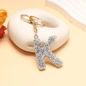 Detailaufnahme des glitzernden Strass Buchstaben K Schlüsselanhängers mit goldenen Beschlägen.