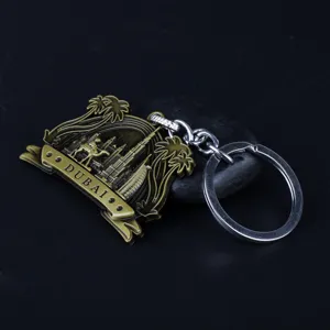 Dubai metal keychain featuring camel and landmark architecture design. Detail view of souvenir.