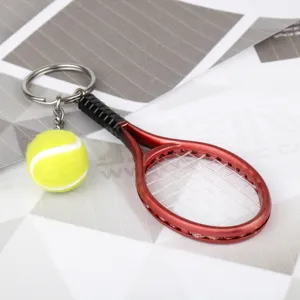Primo piano dettagliato del portachiavi con mini racchetta da tennis rossa e palla.