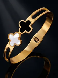 Gold stainless steel double clover cuff bracelet with mother of pearl and black enamel inlay.