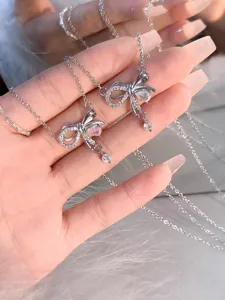 Primer plano detallado del collar de plata con lazo y colgantes de circonita brillante.