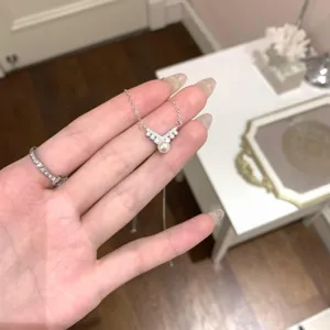Detalle de un collar con colgante de perla en plata de ley con diamantes de circón.