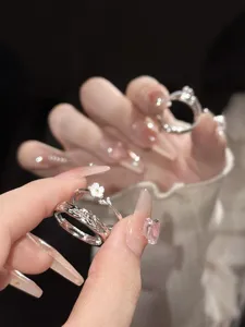 Detalle de anillo de pareja margarita en plata S925, diseño de nicho elegante.