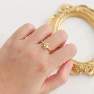 Elegante anillo cuadrado de piedra amarilla con banda trenzada, delicada joya de plata.