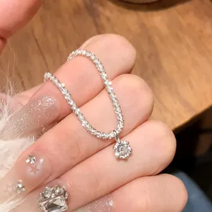 Close-up detail of sparkling sterling silver star-cut chain bracelet with hexagonal diamond pendant.
