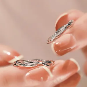 Close-up detail of silver intertwined couple ring with sparkling zircon stones, elegant.