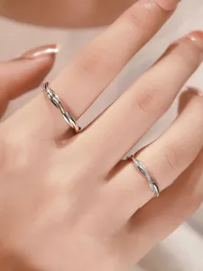 Detail shot of intertwined S925 silver couple rings with sparkling zircon stones.