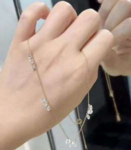 Gros plan détail du collier délicat en argent plaqué or avec de petits pendentifs étincelants.