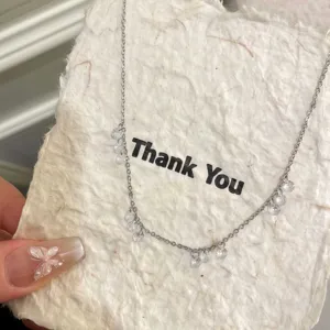Gros plan détaillé d'un fin collier en argent avec des pendentifs brillants et chics.