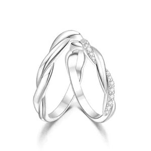 Close-up detail of intertwined twisted silver couple rings sparkling with cubic zirconia diamonds.