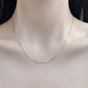 Detailansicht der eleganten Roségold-Boxkettenhalskette, die am Hals getragen wird.
