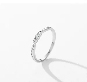 Anillo minimalista de plata esterlina S925 con tres piedras delicadas y detalles curvos elegantes.