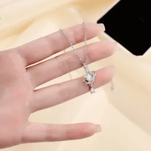 Primer plano del collar con colgante de estrella y luna en plata con detalles brillantes de circonita.