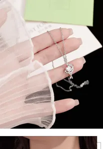 Primer plano de un collar con colgante de estrella y plata esterlina en un modelo de mano.