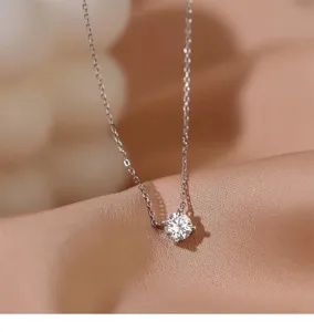 Primer plano detallado de un brillante collar con colgante solitario sobre satén.