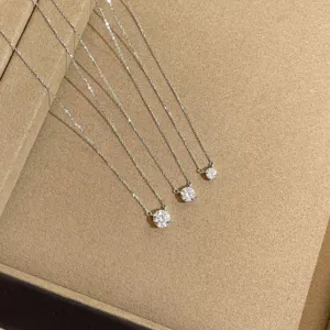 Detalle de primer plano de tres brillantes collares de plata esterlina con circonita solitaria.