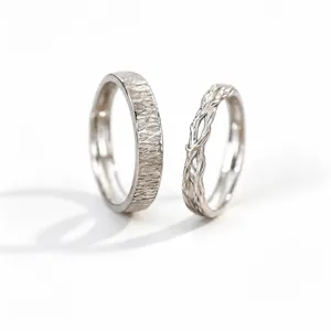 Vista detallada de anillos de pareja de plata S999 con diseño de corteza y vid única.
