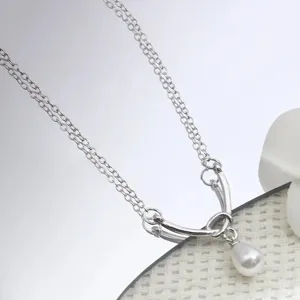 Primer plano detallado del collar de doble cadena de plata con un elegante colgante.