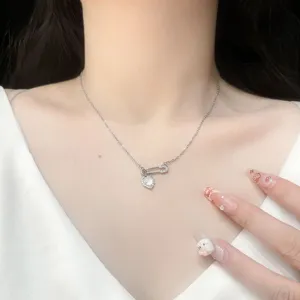 Close-up detail of the silver safety pin heart zircon necklace, delicate clavicle chain view.