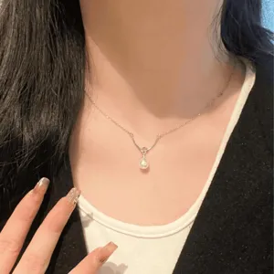 Primer plano detalle del collar minimalista de plata con perla elegante en el cuello.