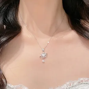Primer plano detallado del collar con dije de planeta plateado y estrella brillante.