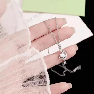 Detalle en primer plano del collar con colgante de corazón estrella y luna plateado.
